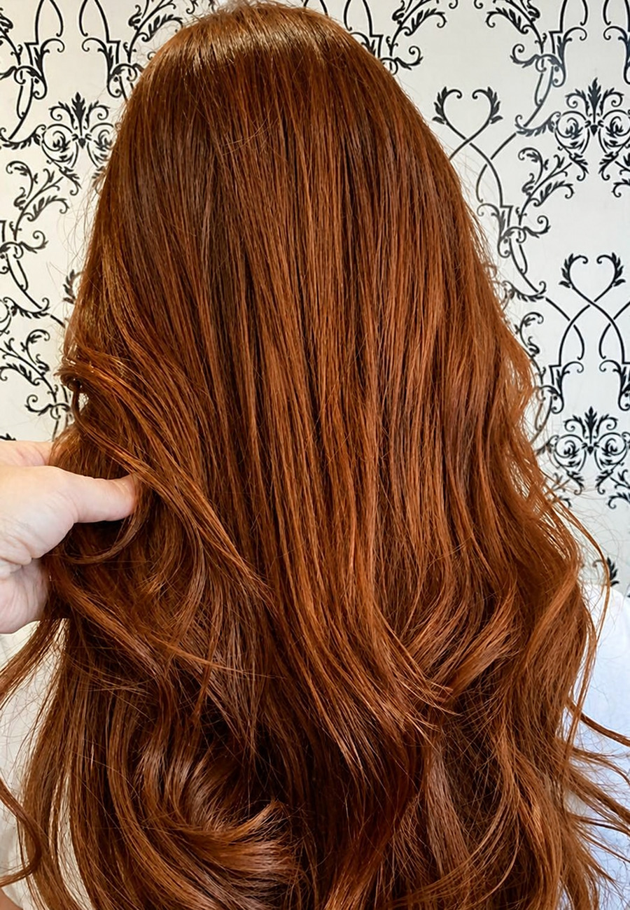 Long auburn hair in glossy waves by Vered Valensi